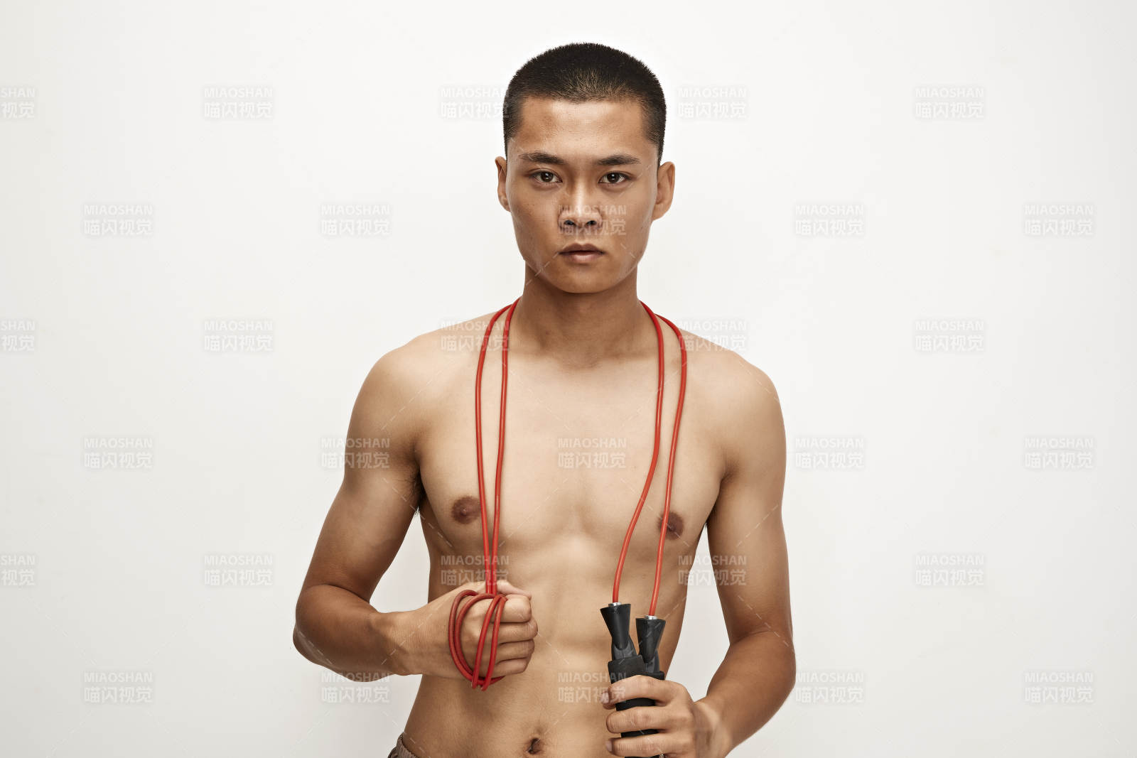 白色背景下手持運動跳繩的亞洲健身男士形象