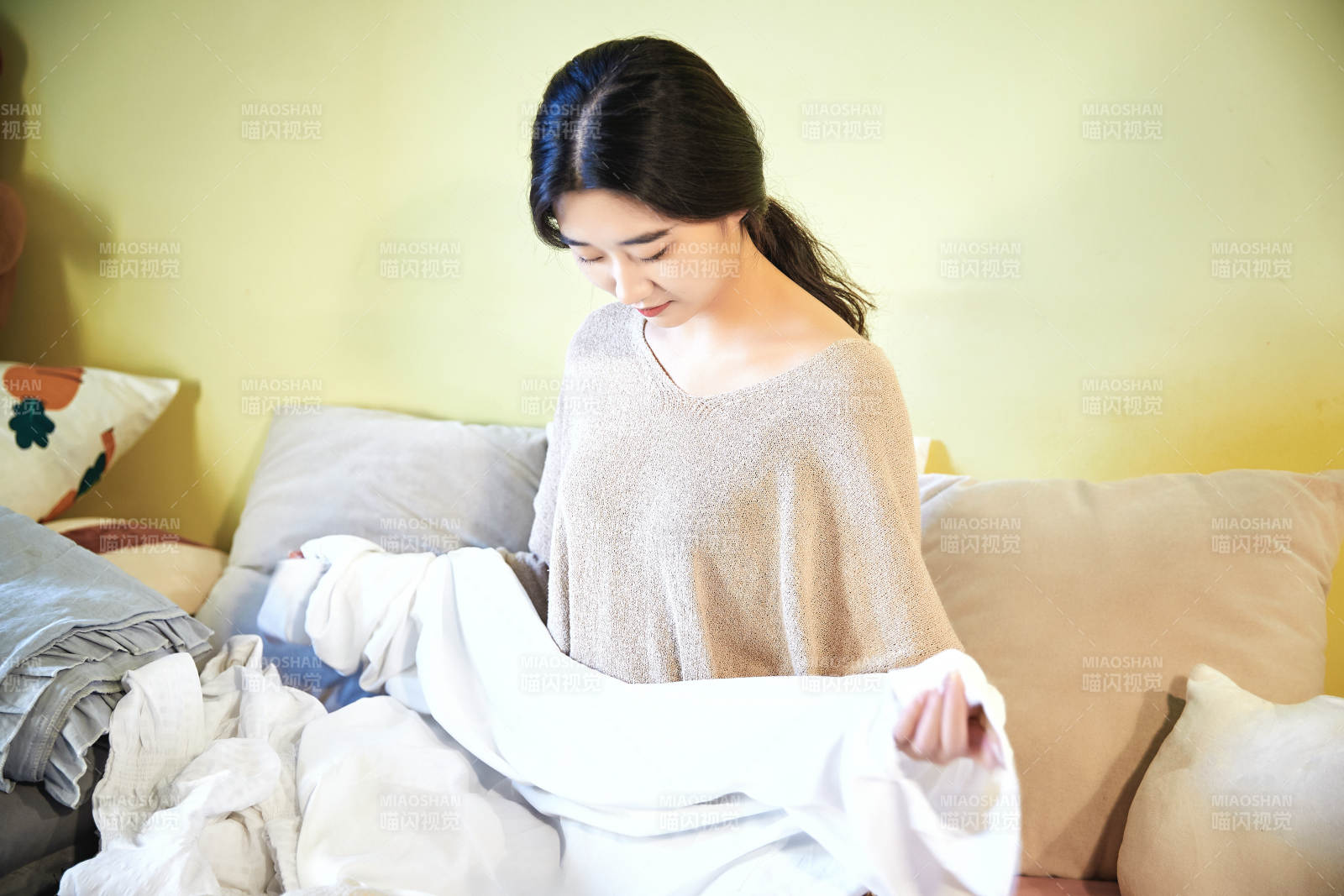 在沙發(fā)床上整理行裝的年輕亞洲女性