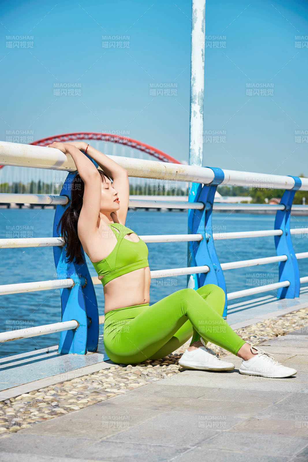 戶外河畔公園做拉伸有氧運動的亞洲女性