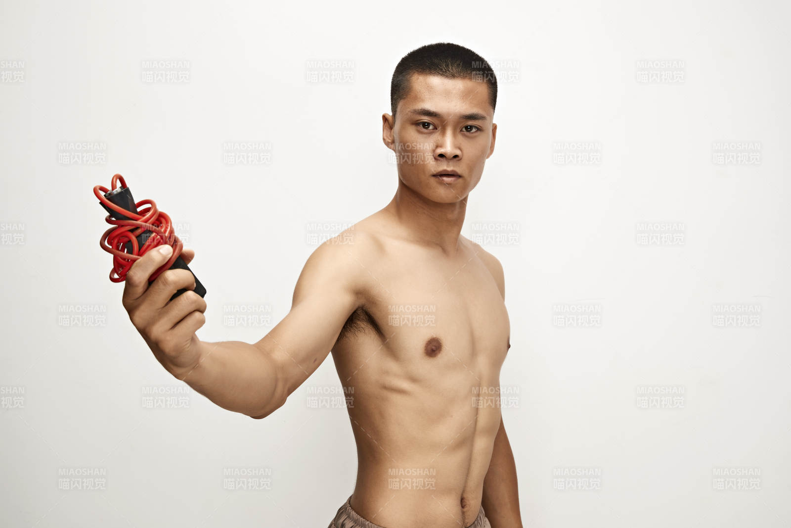 白色背景下手持運動跳繩的亞洲健身男士形象