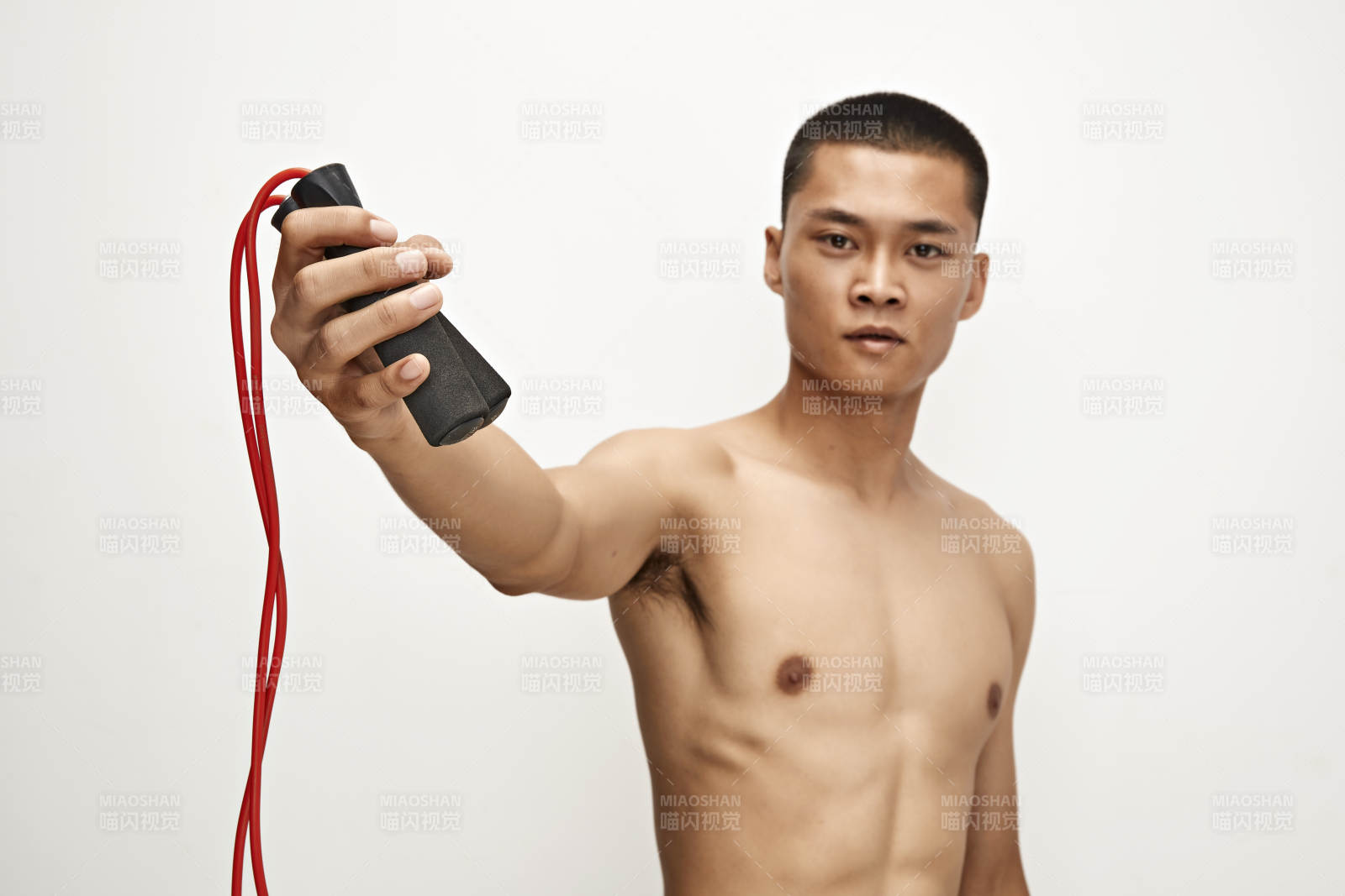 白色背景下手持運動跳繩的亞洲健身男士形象