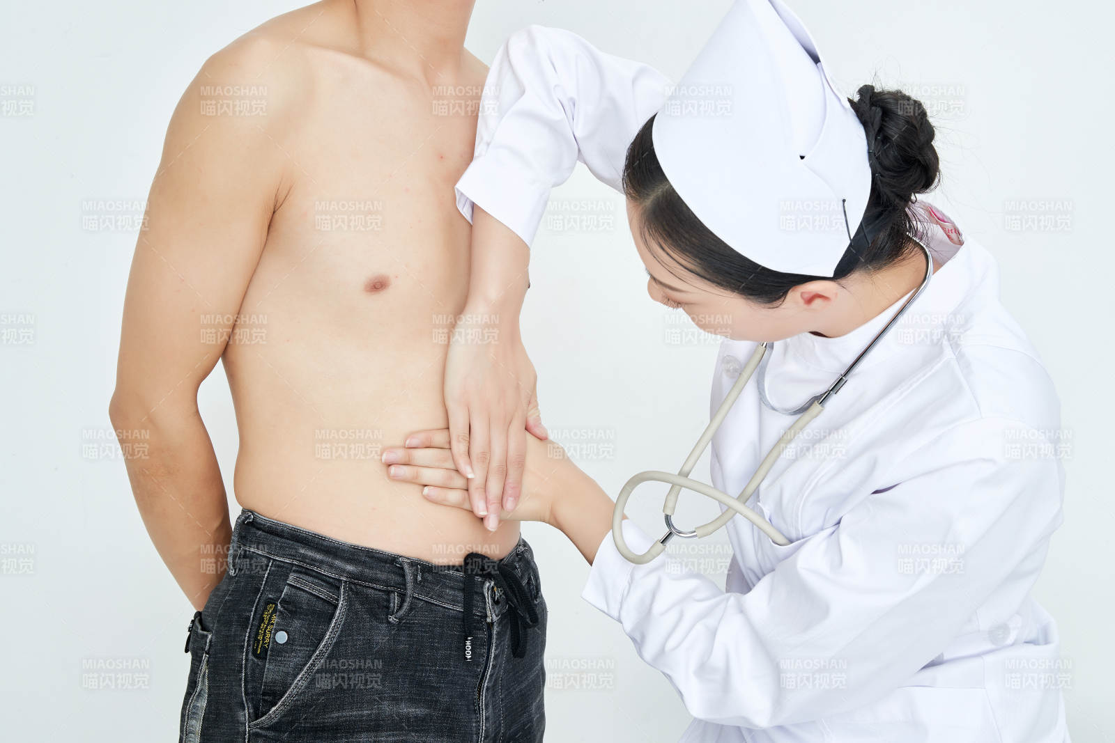 年輕的女性醫護人員為患者進行身體按壓檢查