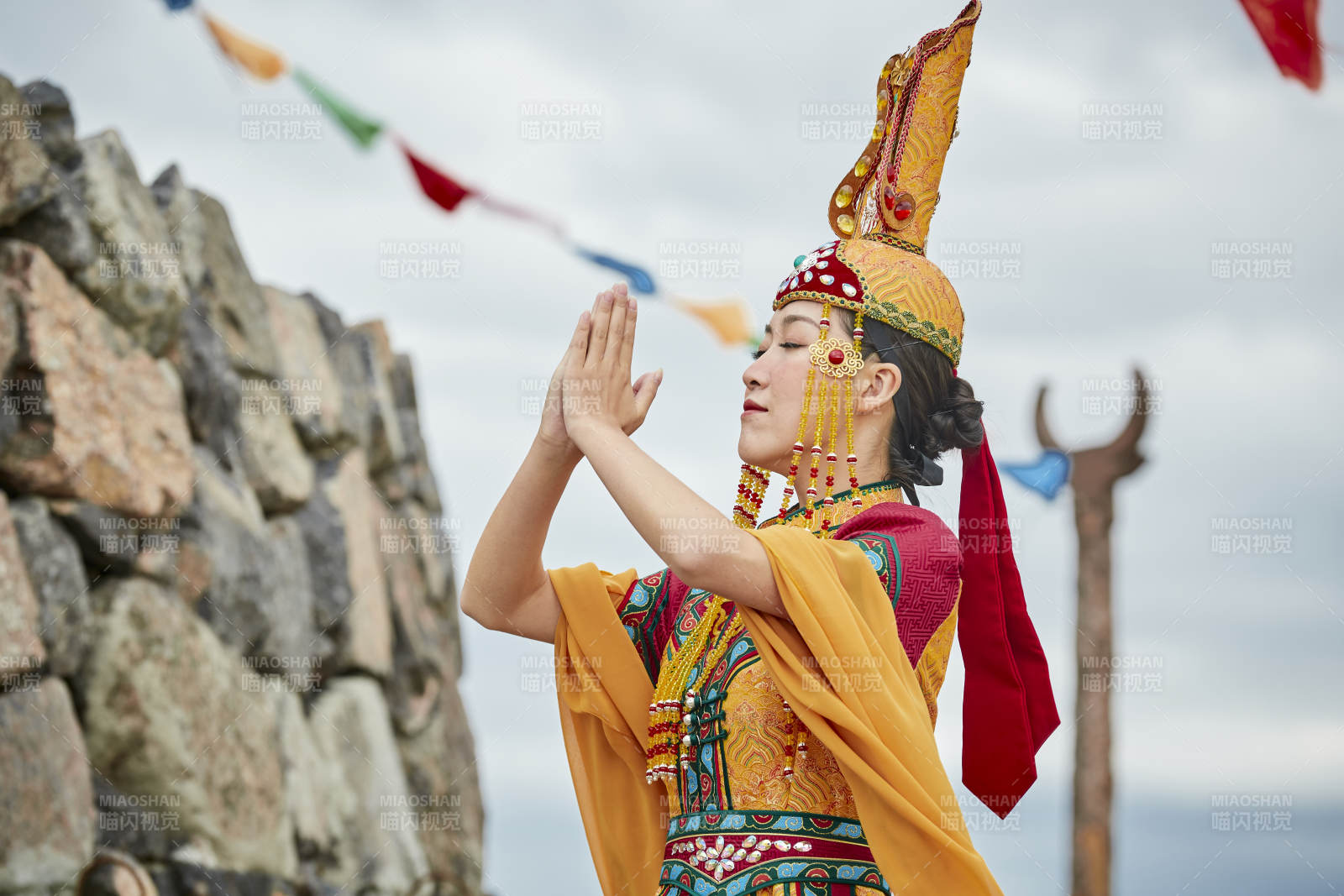 草原上敖包前身穿豪華蒙古族服飾的蒙族少女