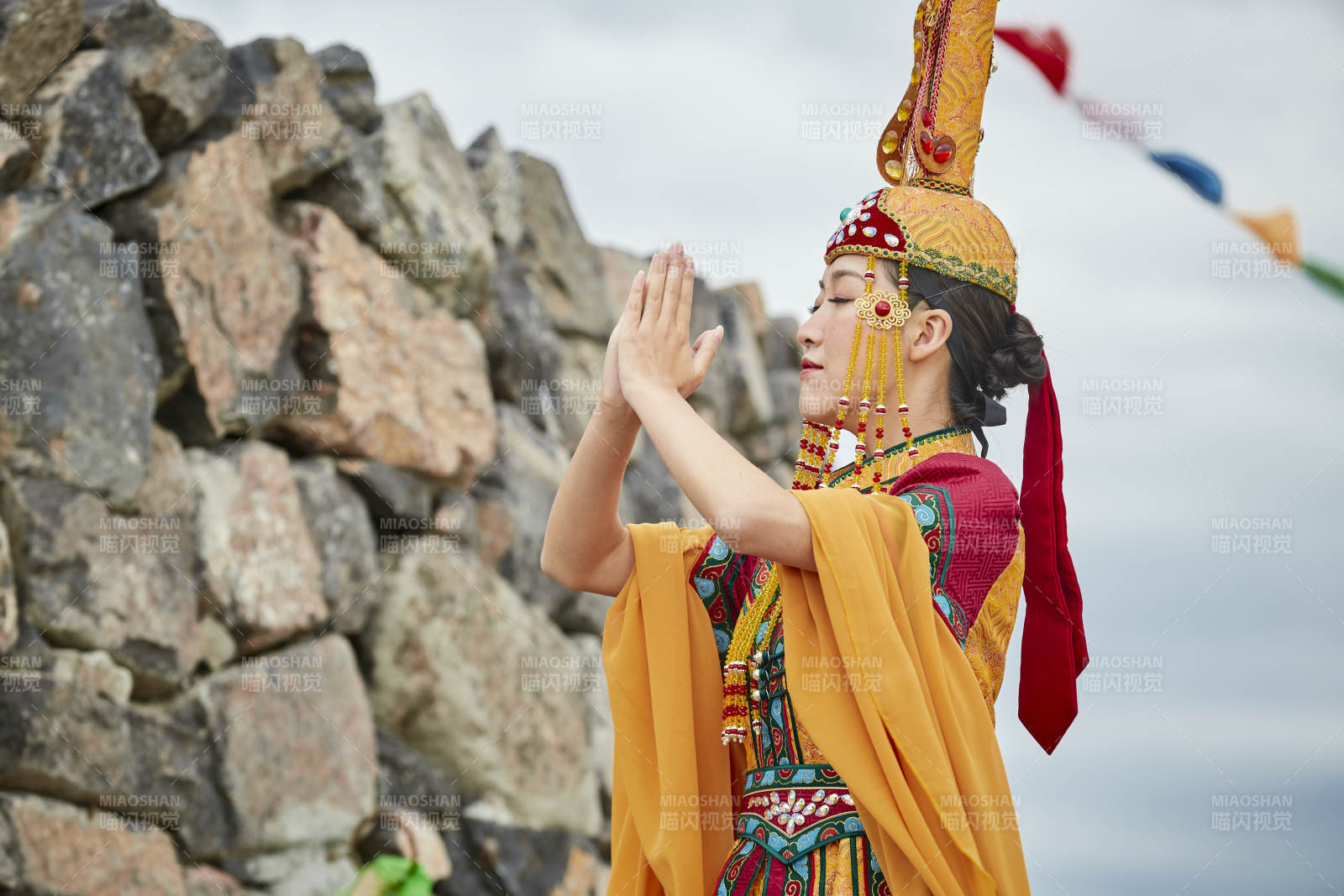 草原上敖包前身穿豪华蒙古族服饰的蒙族少女