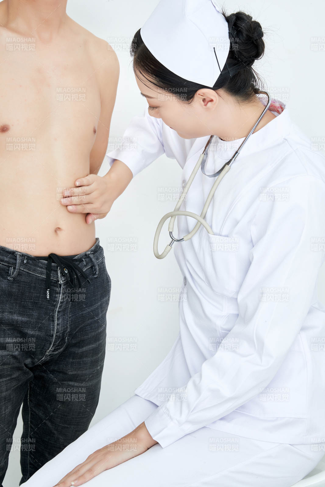 年輕的女性醫(yī)護人員為患者進行身體按壓檢查