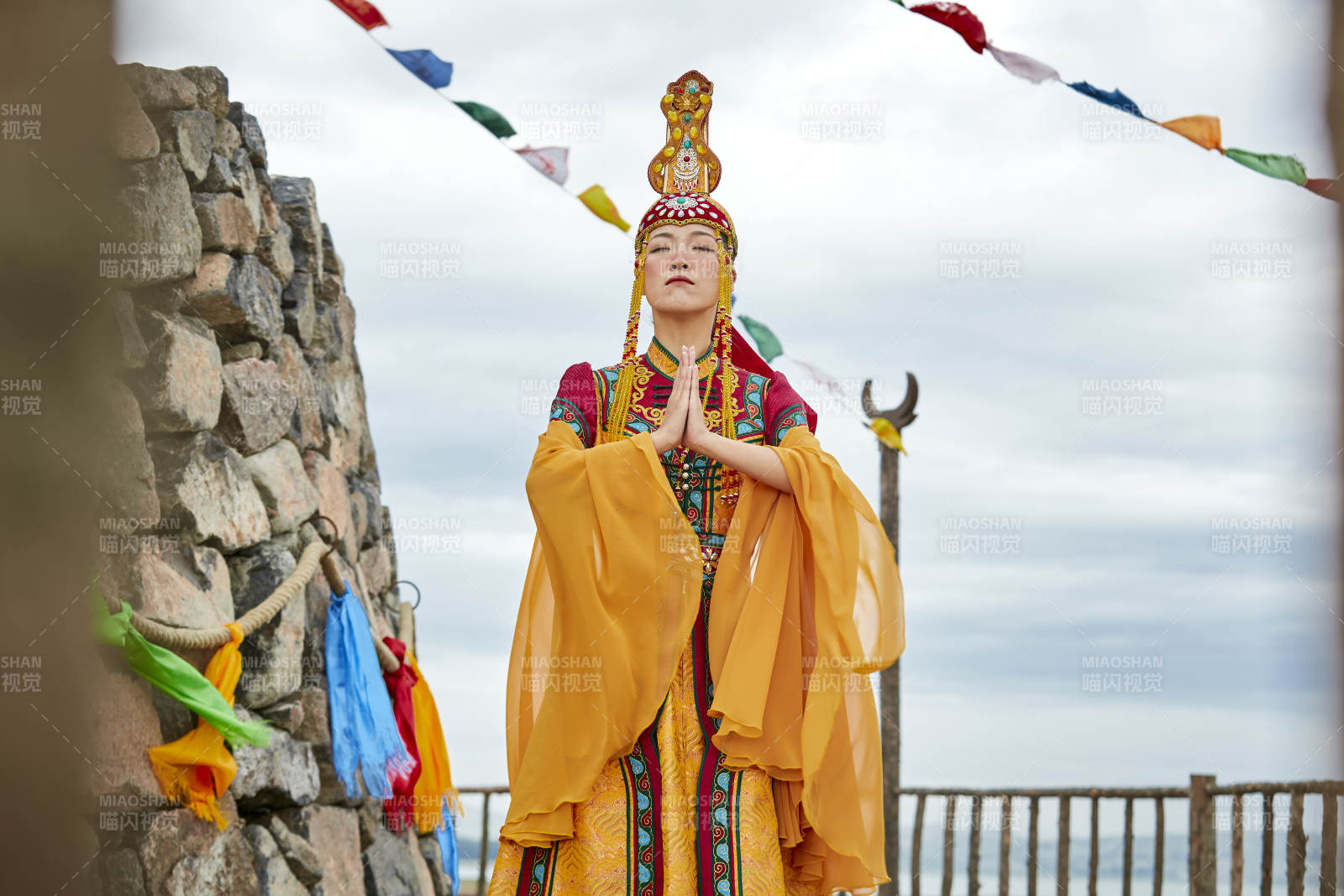草原上敖包前身穿豪華蒙古族服飾的蒙族少女