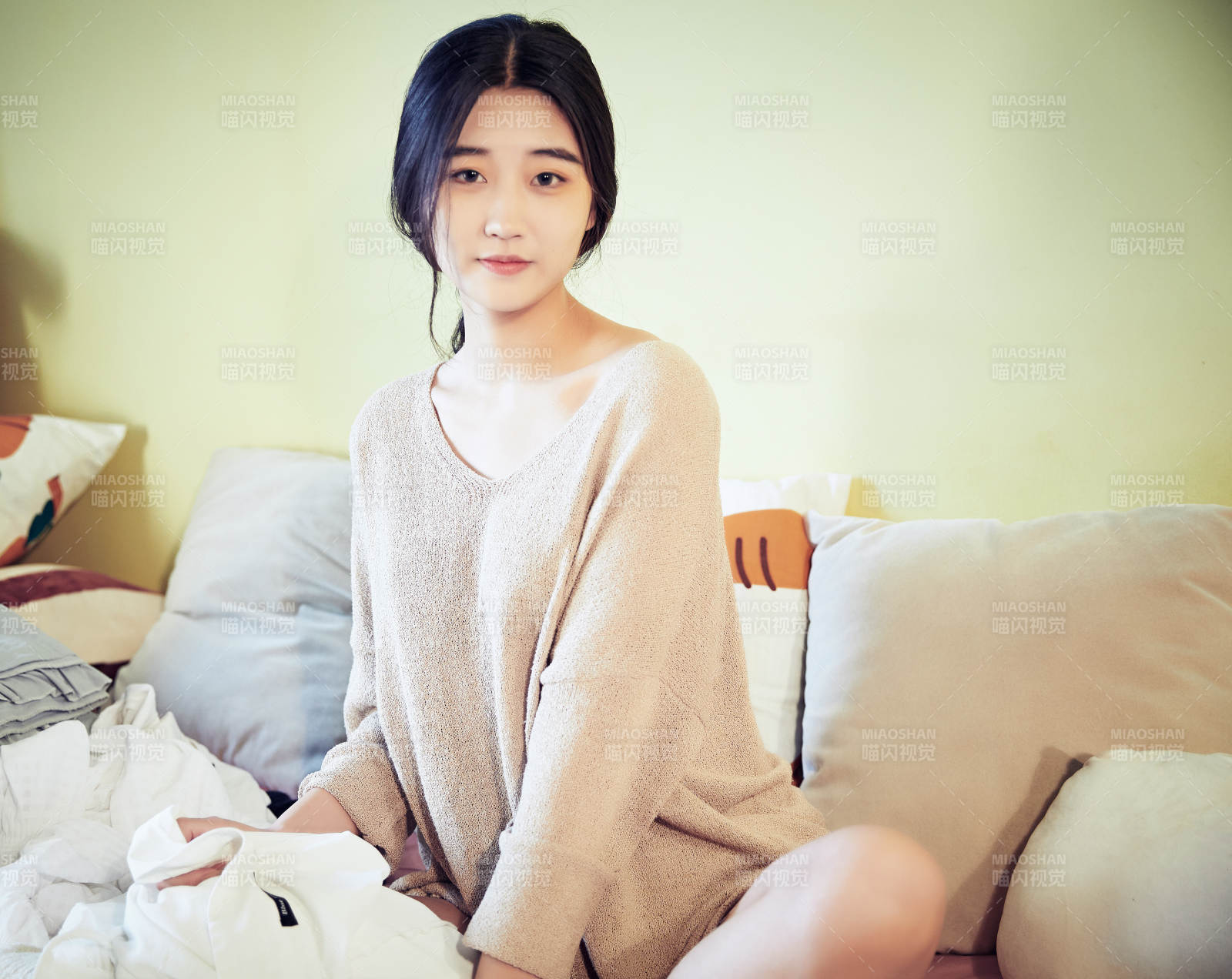 在沙发床上整理行装的年轻亚洲女性