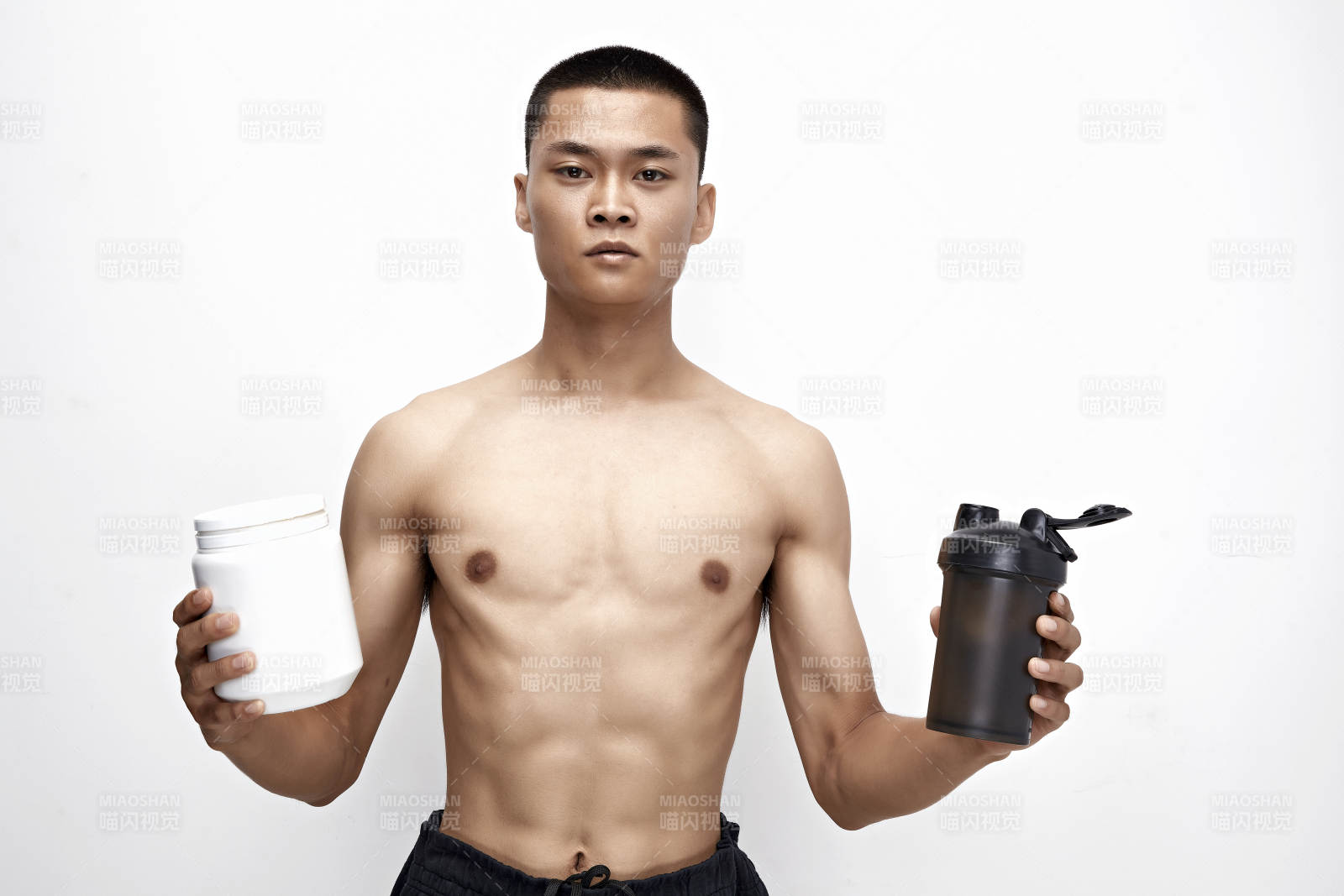 手持蛋白粉的身材勻稱肌肉扎實的亞洲男性
