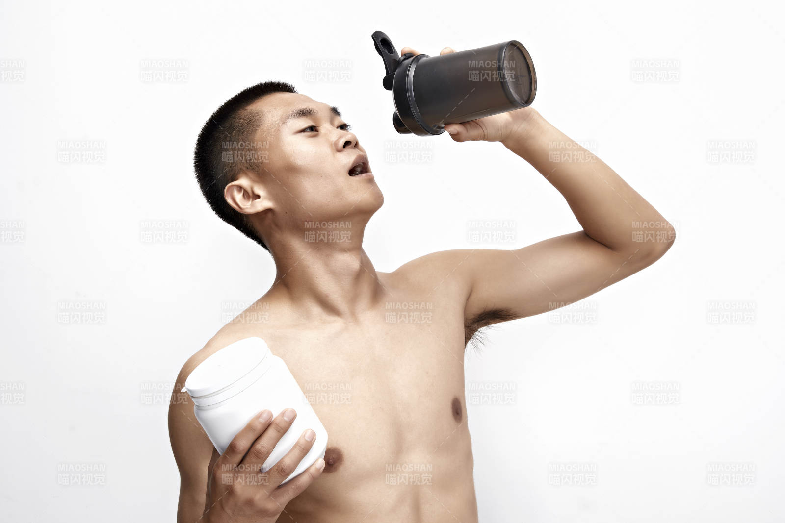 手持蛋白粉的身材勻稱肌肉扎實的亞洲男性