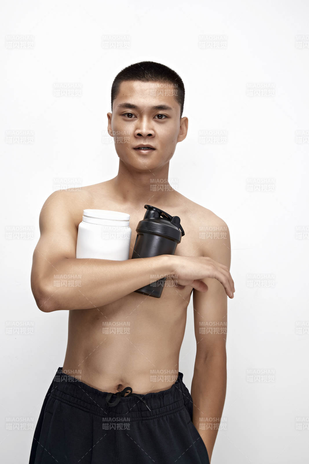 手持蛋白粉的身材勻稱肌肉扎實的亞洲男性