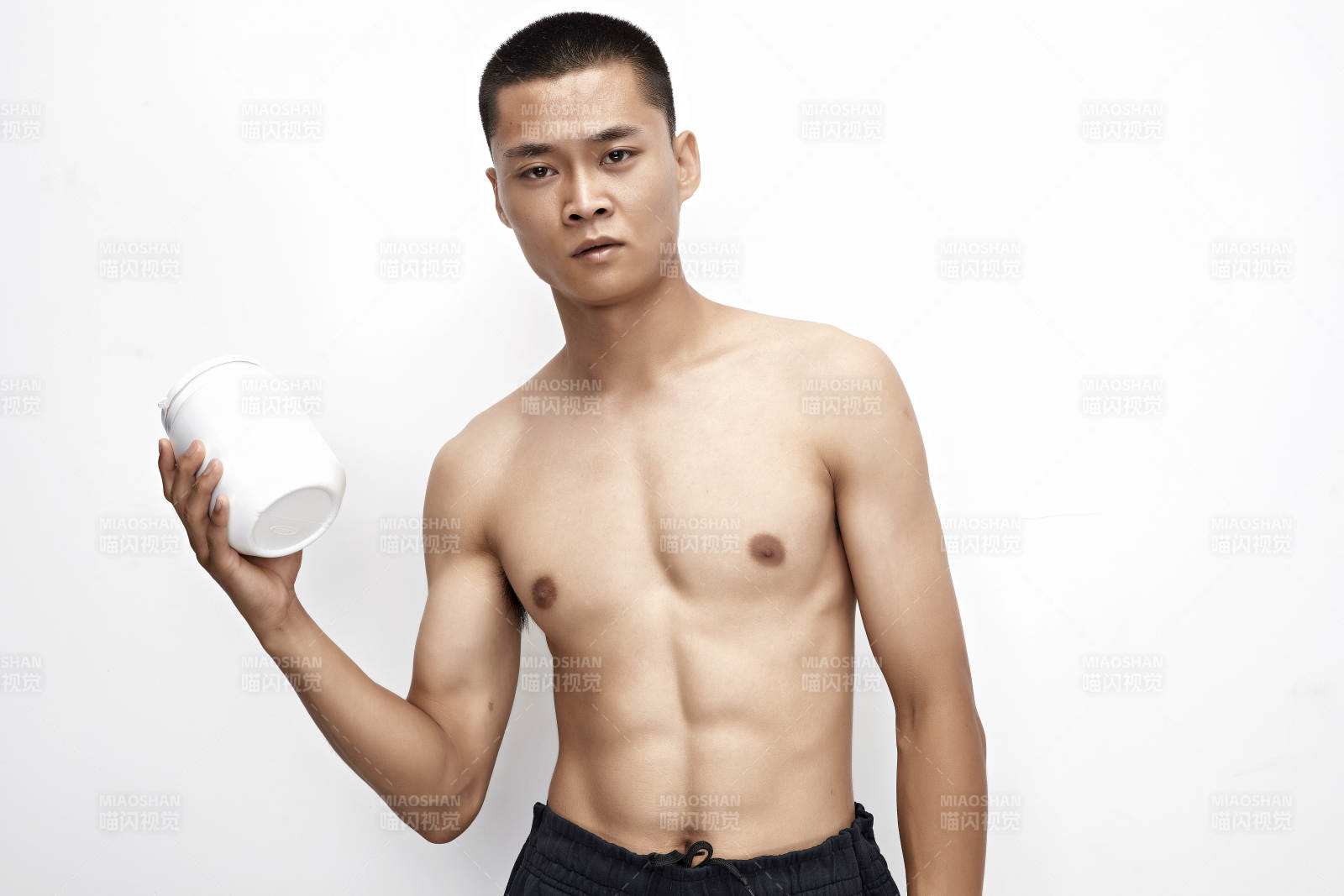 手持蛋白粉的身材勻稱肌肉扎實的亞洲男性