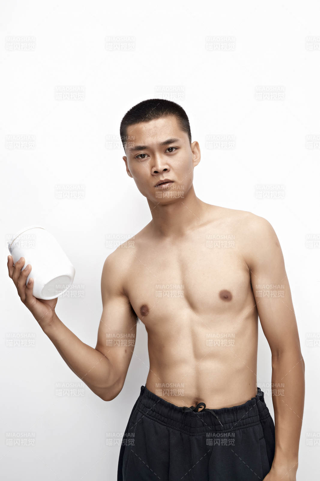 手持蛋白粉的身材勻稱肌肉扎實的亞洲男性