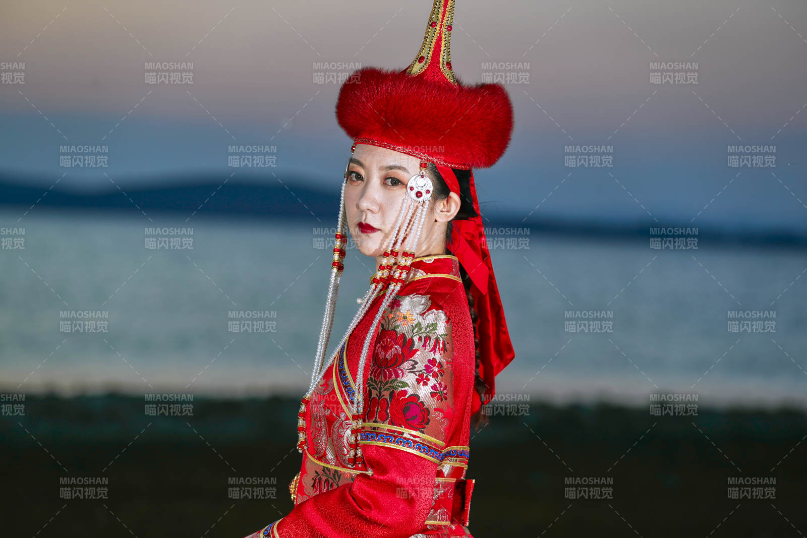 晚霞的草原湖畔穿蒙古族傳統(tǒng)服飾的年輕女性