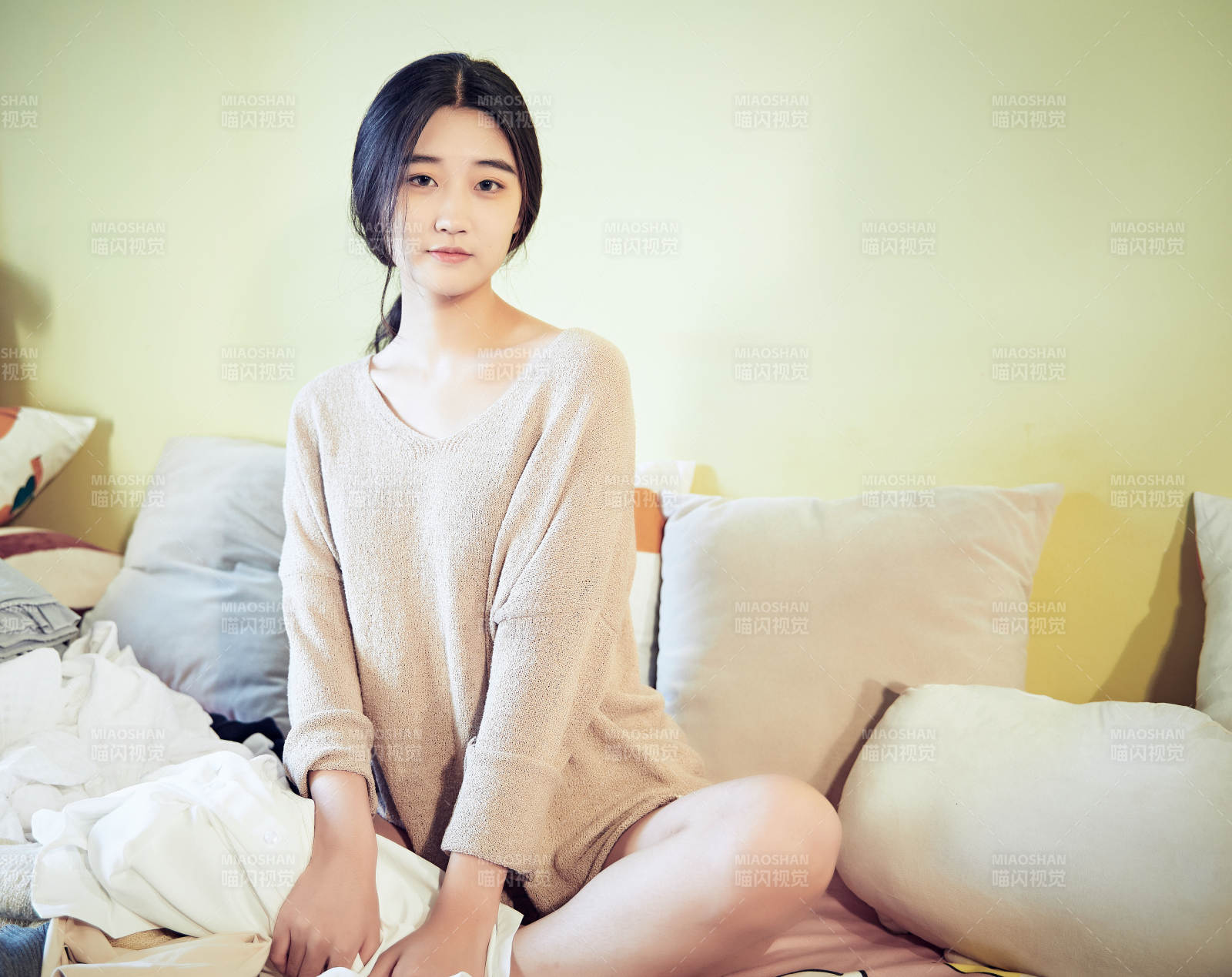 在沙發床上整理行裝的年輕亞洲女性