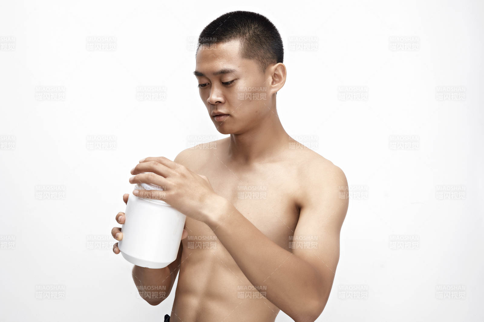 手持蛋白粉的身材勻稱肌肉扎實的亞洲男性