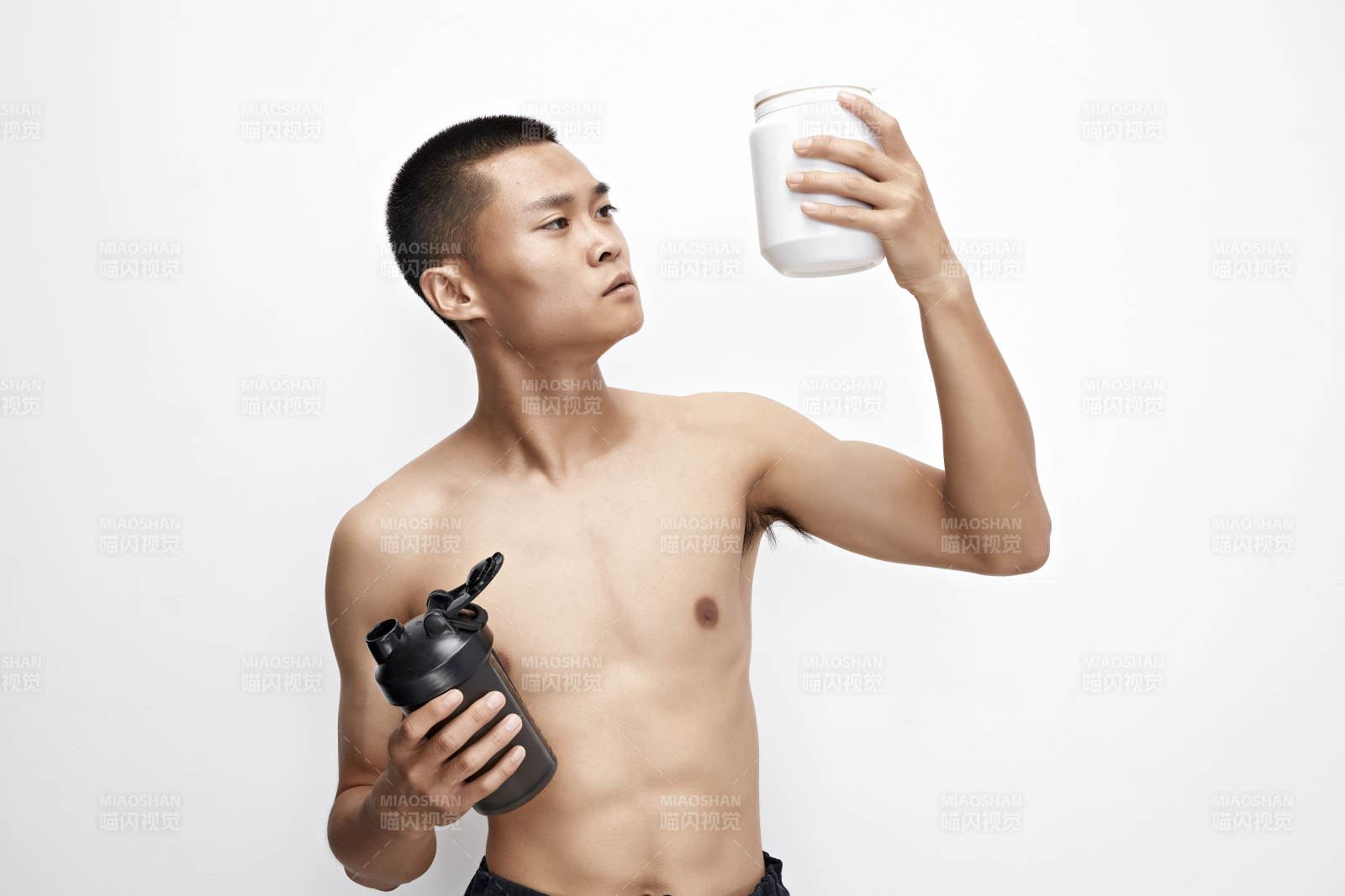手持蛋白粉的身材勻稱肌肉扎實的亞洲男性