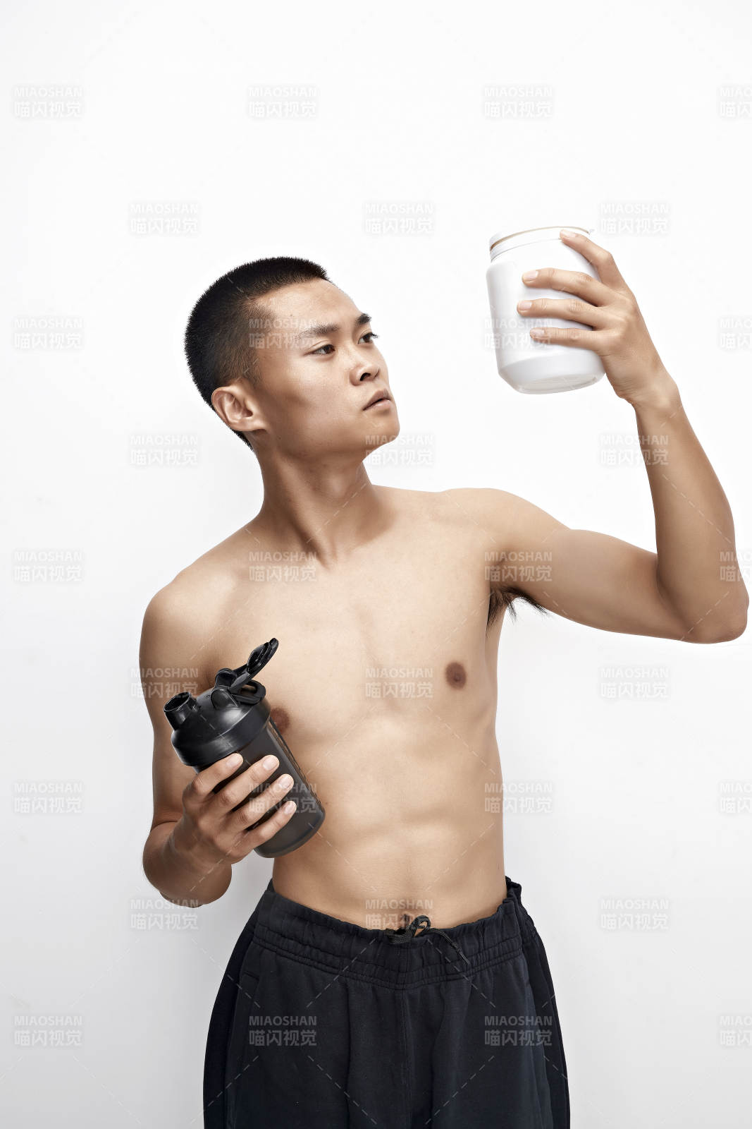 手持蛋白粉的身材勻稱肌肉扎實的亞洲男性