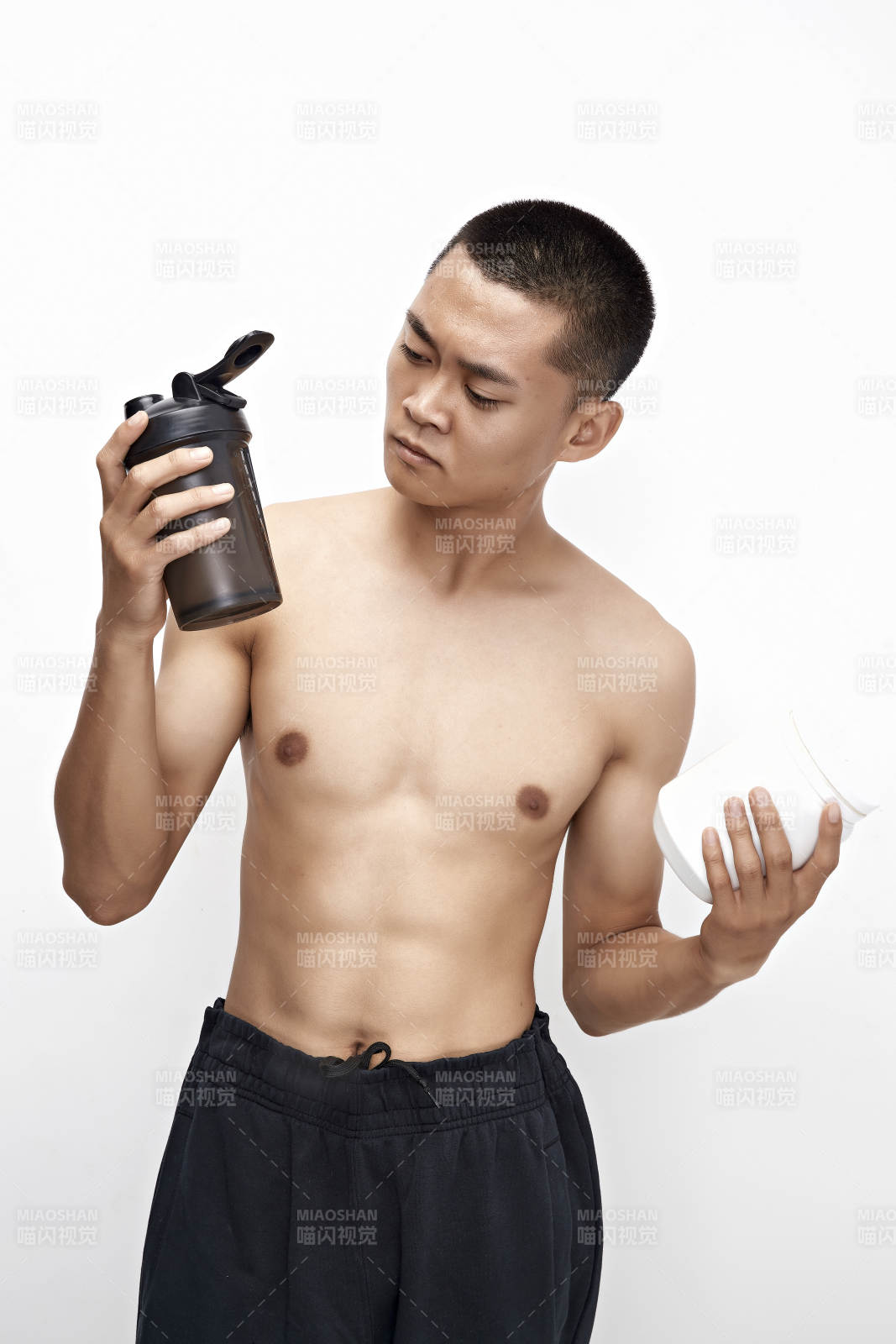 手持蛋白粉的身材勻稱肌肉扎實(shí)的亞洲男性