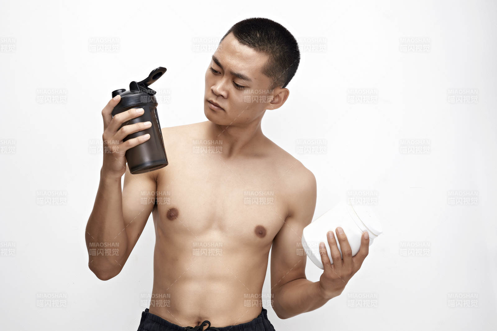 手持蛋白粉的身材勻稱肌肉扎實的亞洲男性