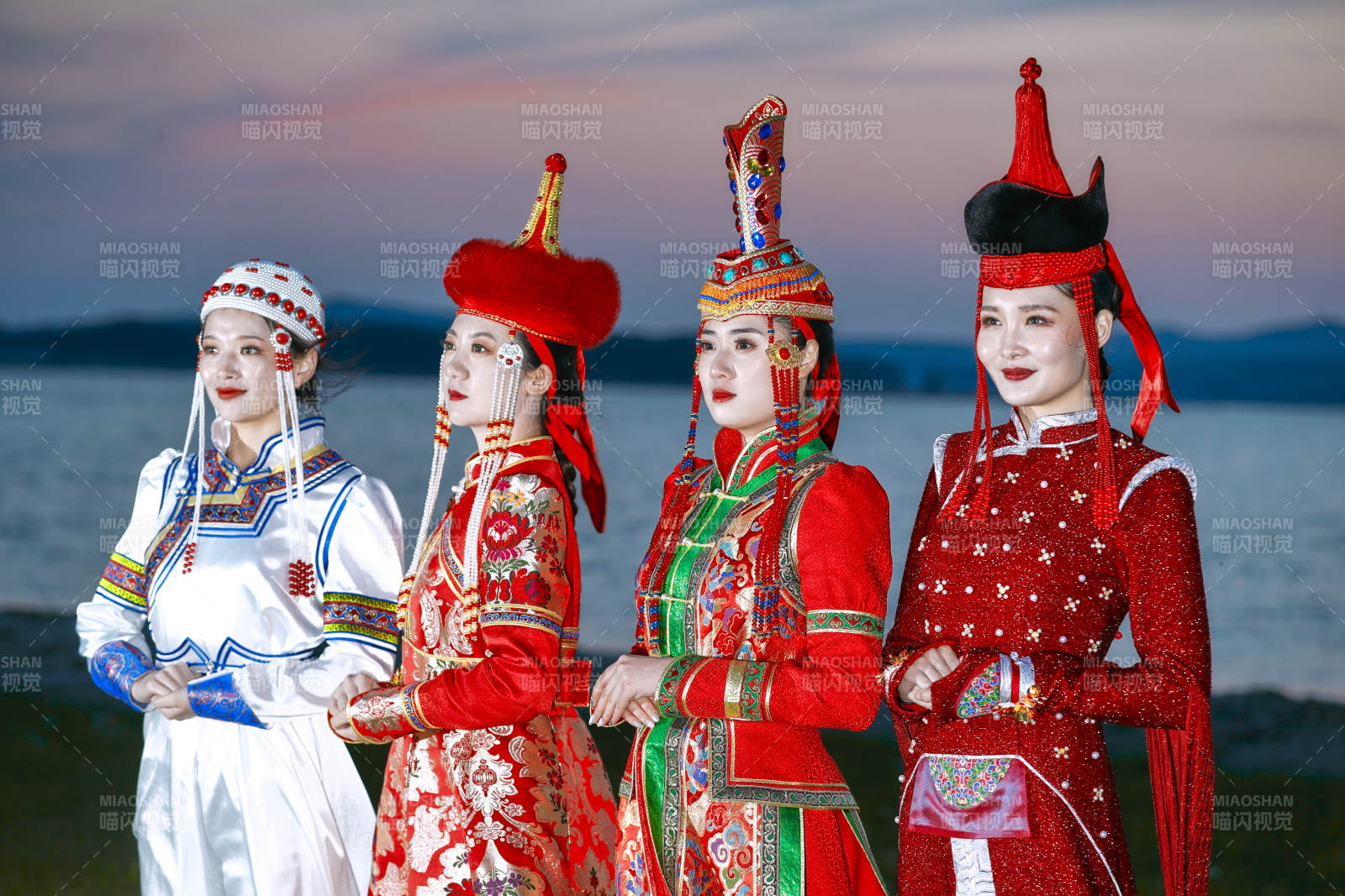 晚霞的草原湖畔穿蒙古族傳統服飾的年輕女性