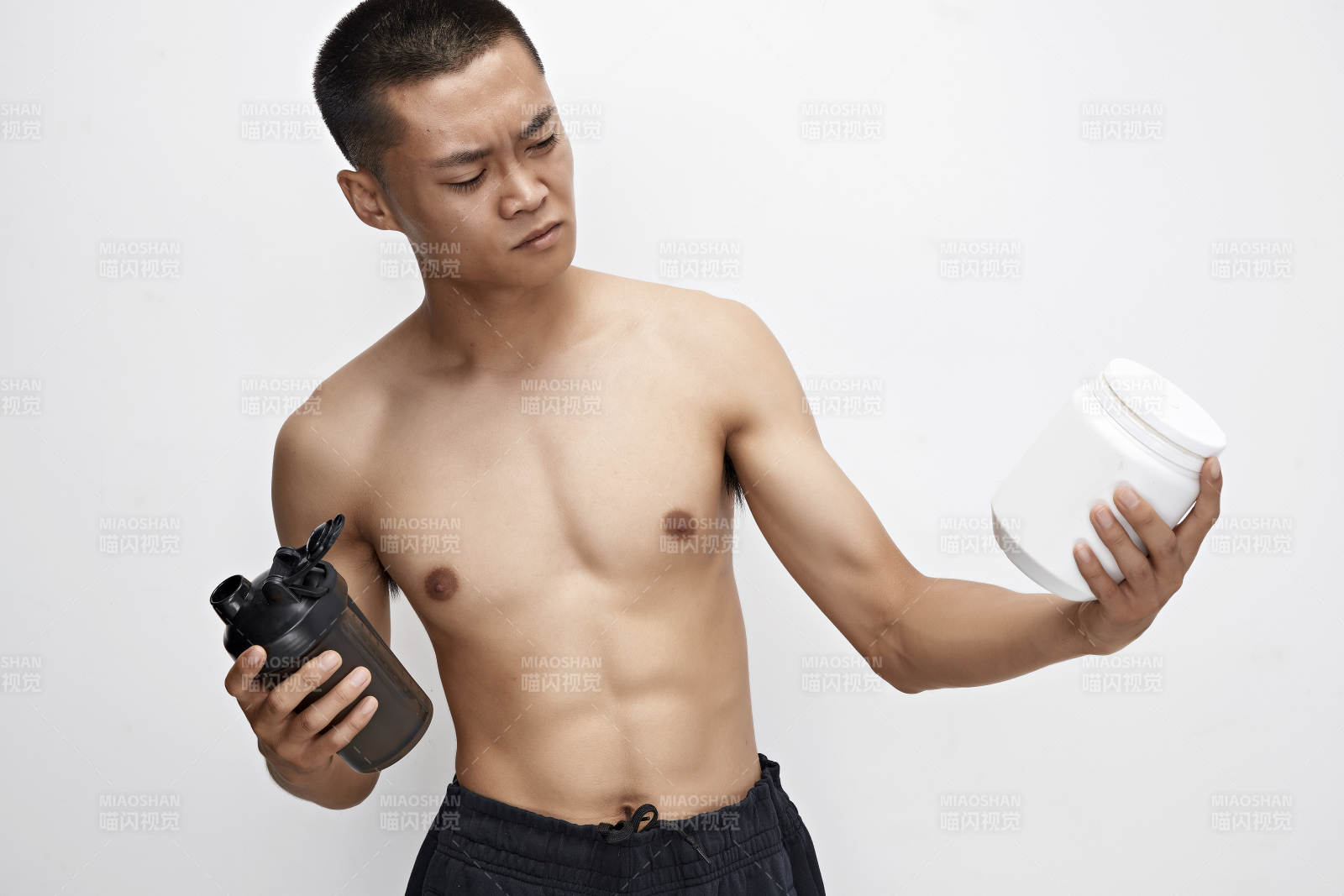 手持蛋白粉的身材勻稱肌肉扎實的亞洲男性