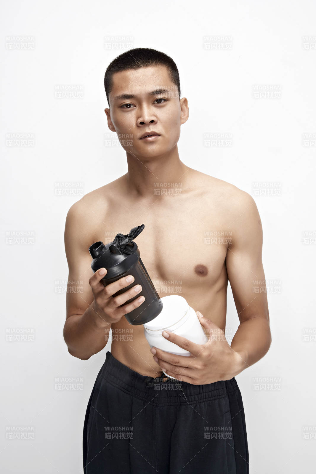 手持蛋白粉的身材勻稱肌肉扎實的亞洲男性