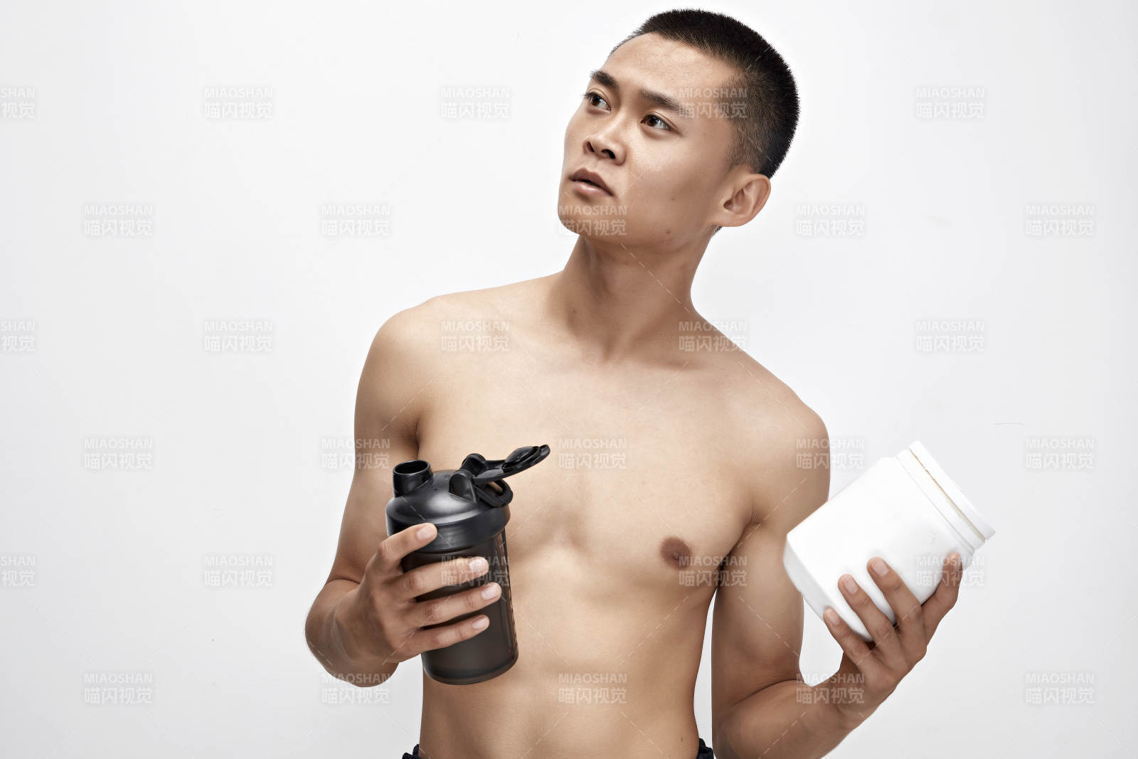 手持蛋白粉的身材勻稱肌肉扎實的亞洲男性