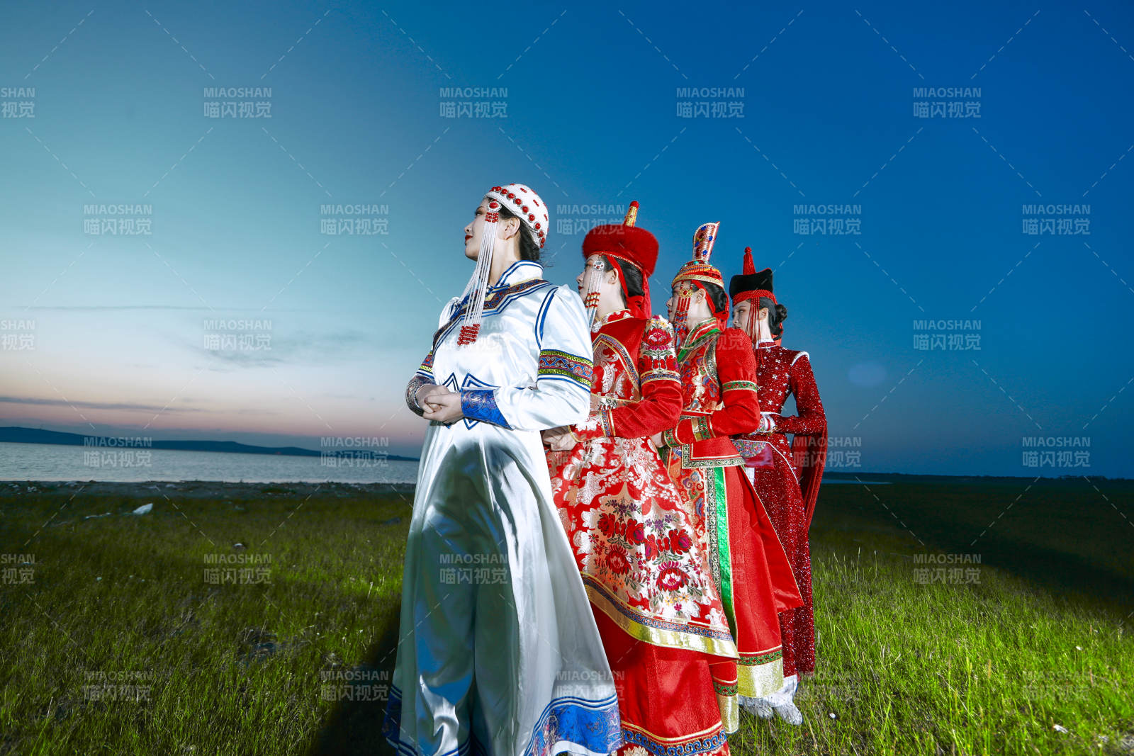 晚霞的草原湖畔穿蒙古族傳統(tǒng)服飾的年輕女性