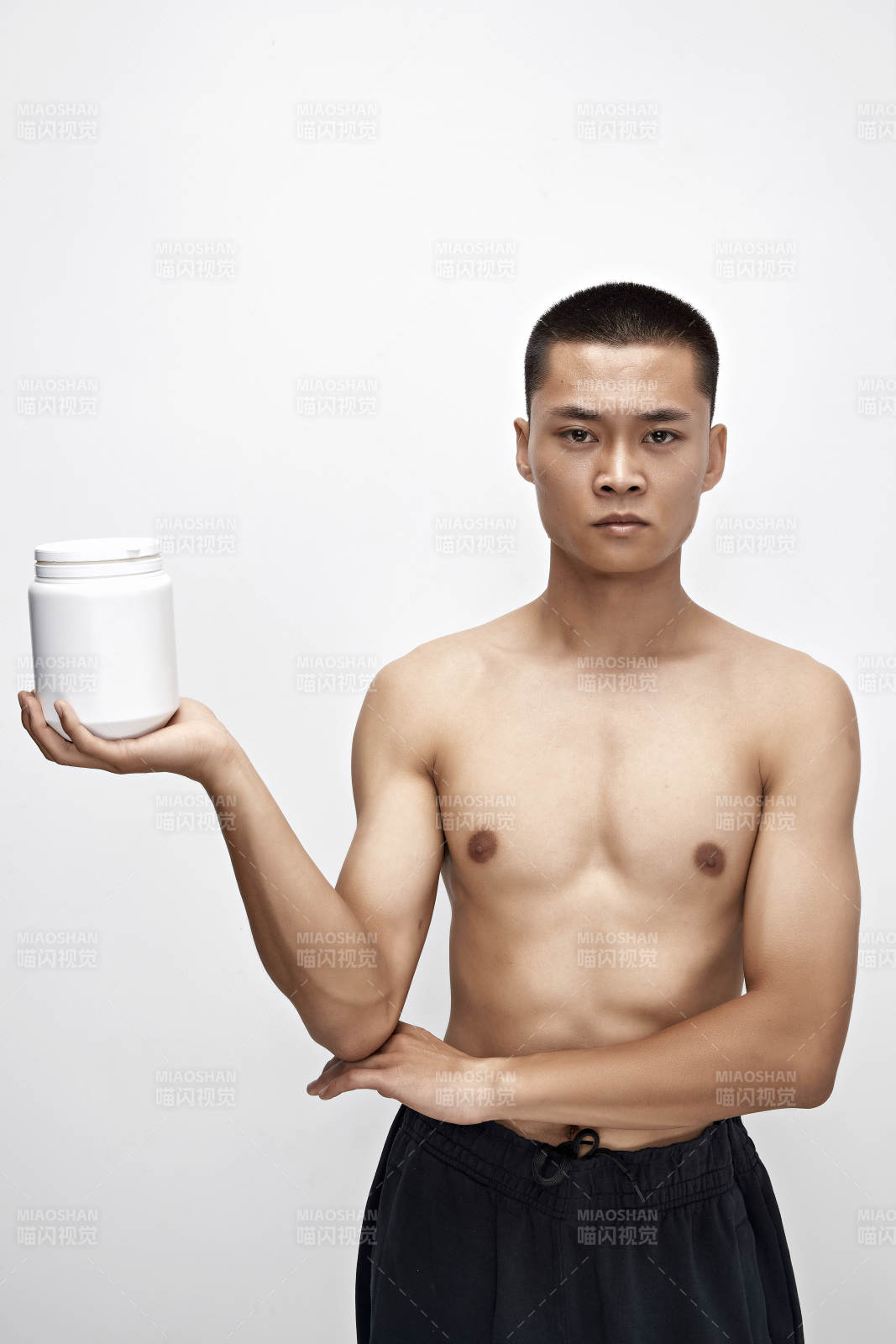 手持蛋白粉的身材勻稱肌肉扎實的亞洲男性