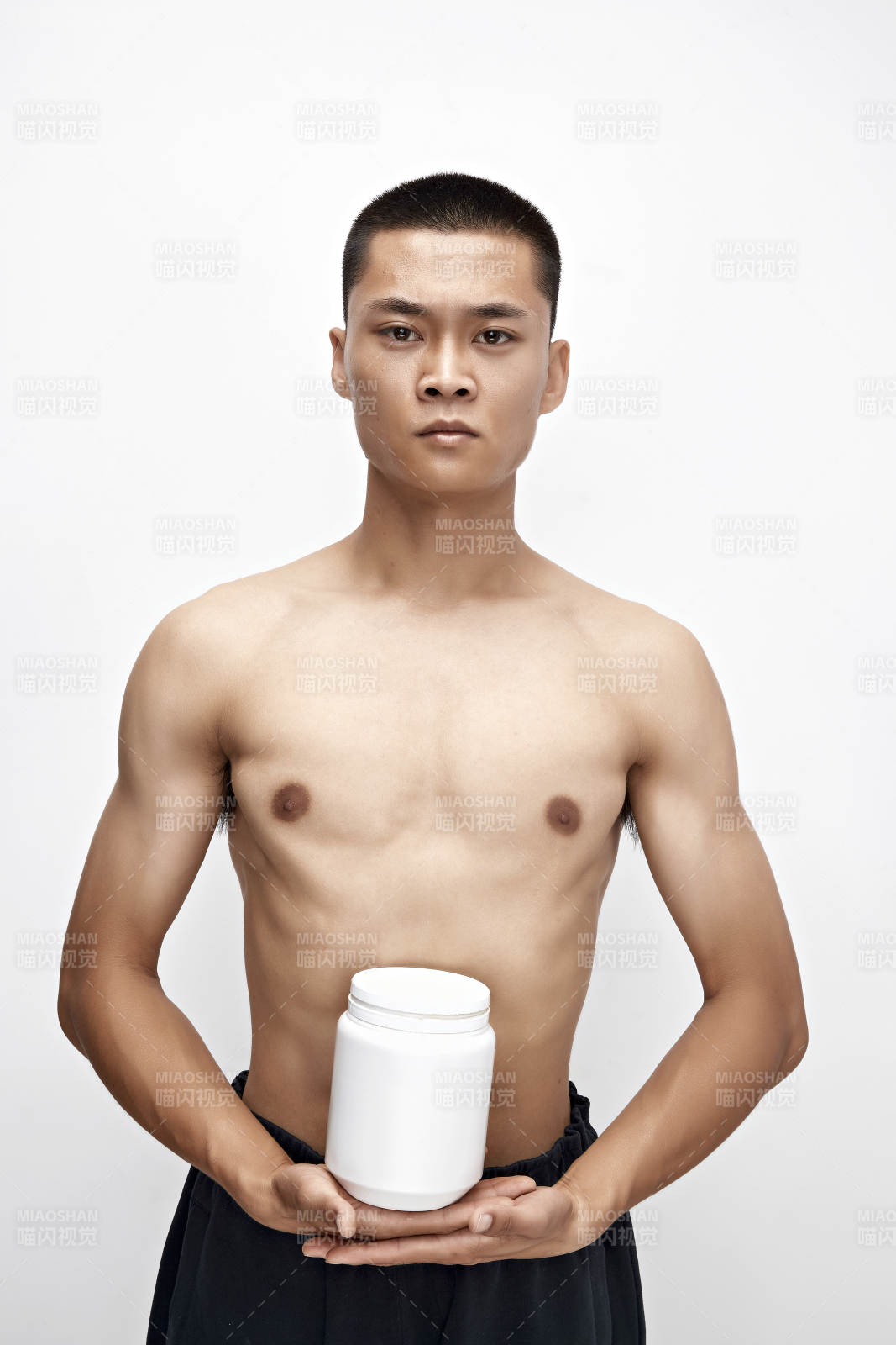 手持蛋白粉的身材勻稱肌肉扎實的亞洲男性