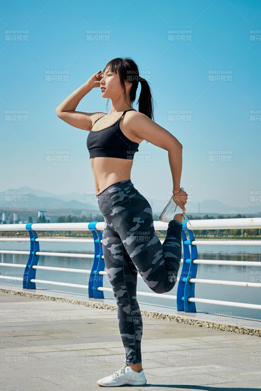 戶外河畔公園做拉伸有氧運動的亞洲女性