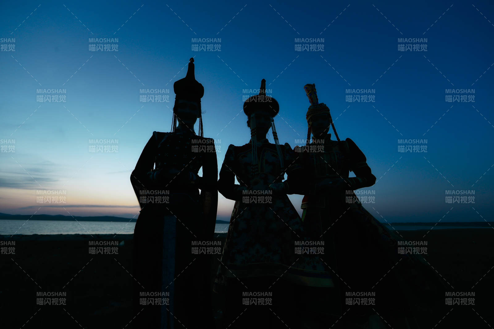 晚霞的草原湖畔穿蒙古族傳統服飾的年輕女性