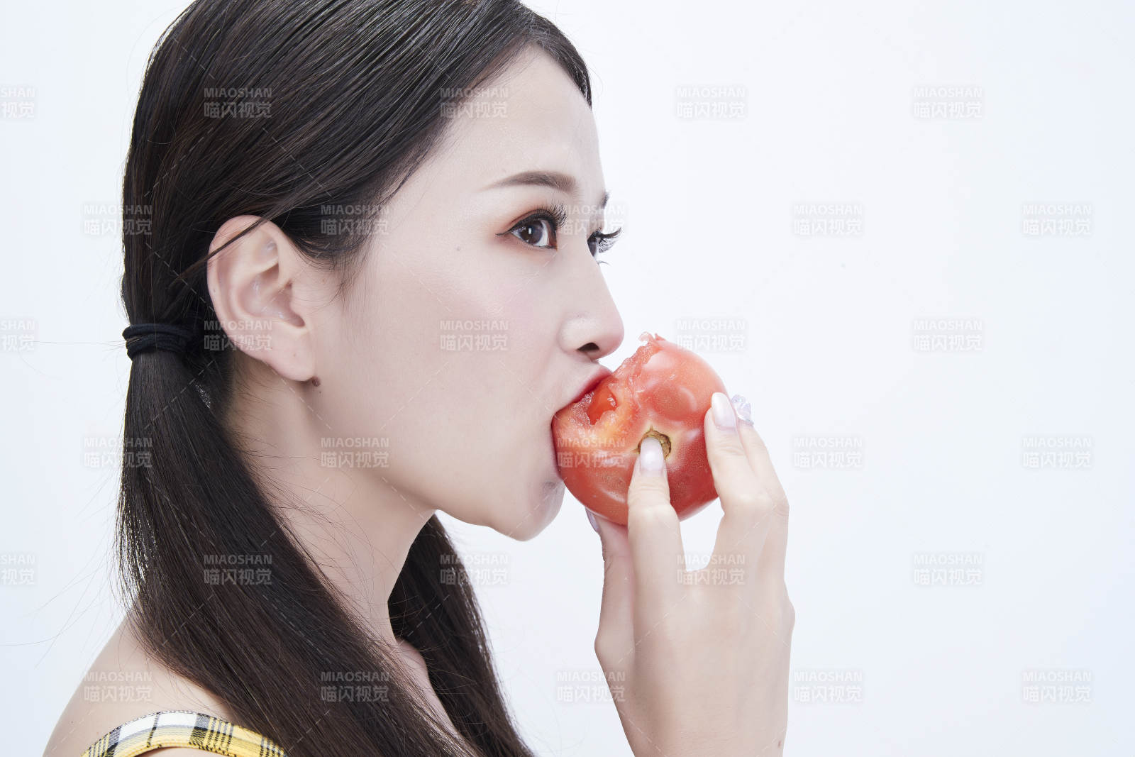 啃咬番茄身穿格子吊带裙的亚洲可爱少女人像图片