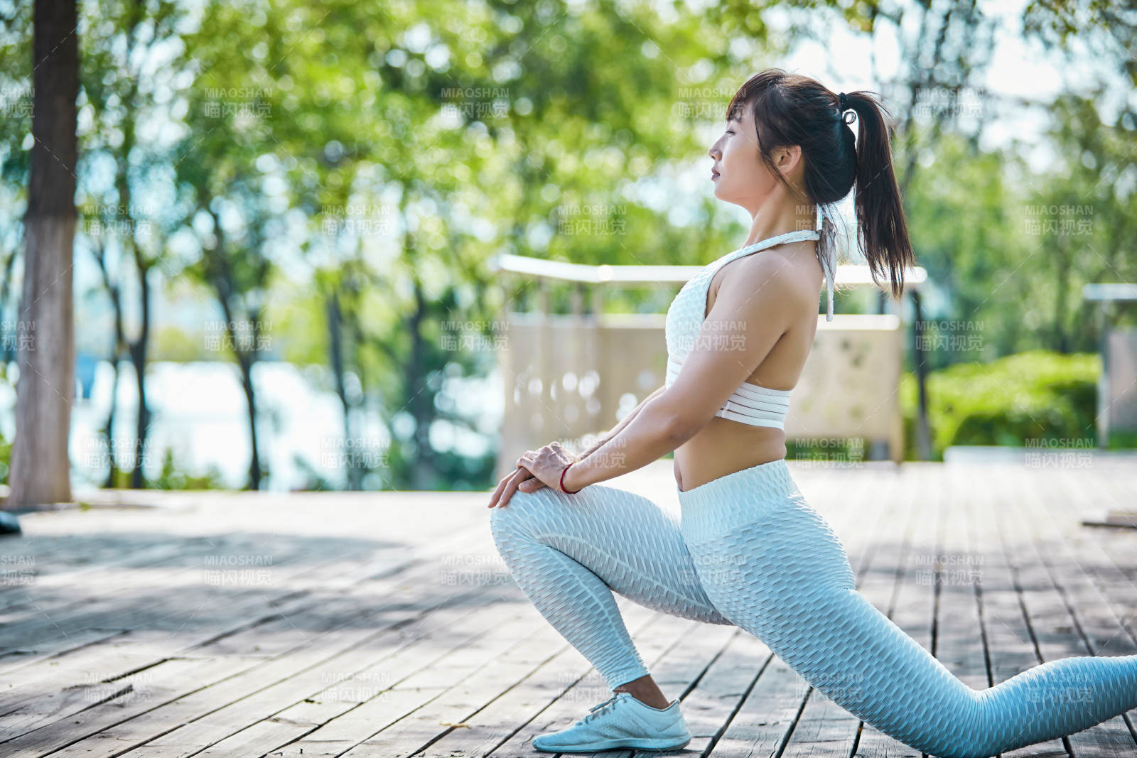 湖畔公園做瑜伽動作的亞洲年輕女性