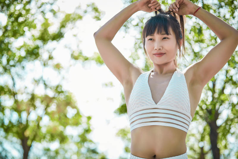 湖畔公园做瑜伽动作的亚洲年轻女性