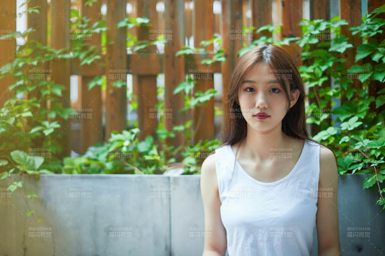 院子里坐在長椅上閱讀書籍的亞洲長發少女