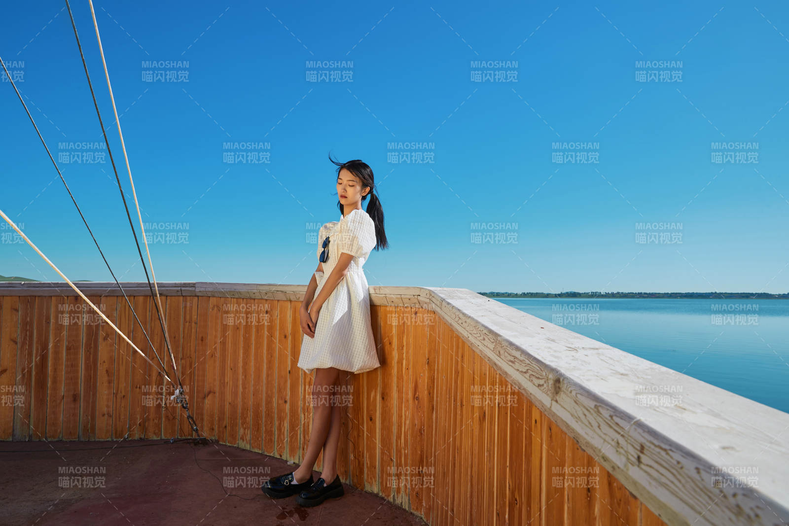 在湖畔木制帆船上的亚洲美女图片