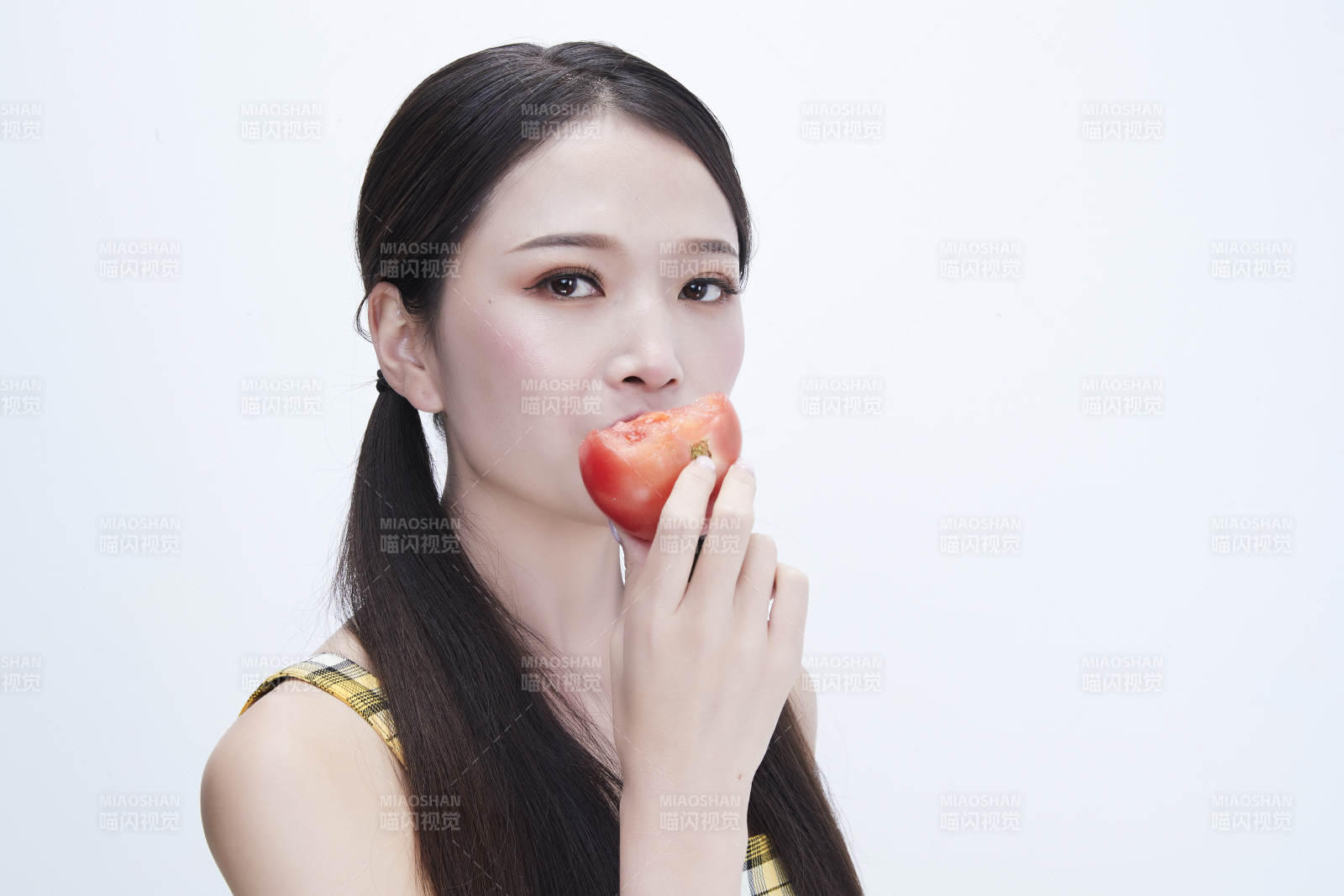 啃咬番茄身穿格子吊帶裙的亞洲可愛少女人像