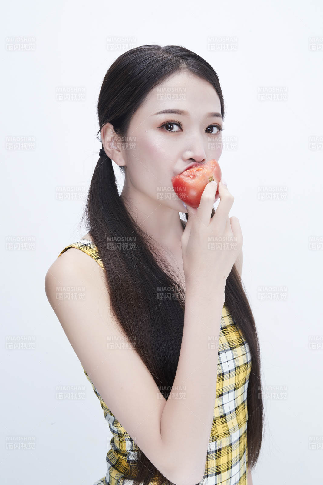 啃咬番茄身穿格子吊帶裙的亞洲可愛少女人像