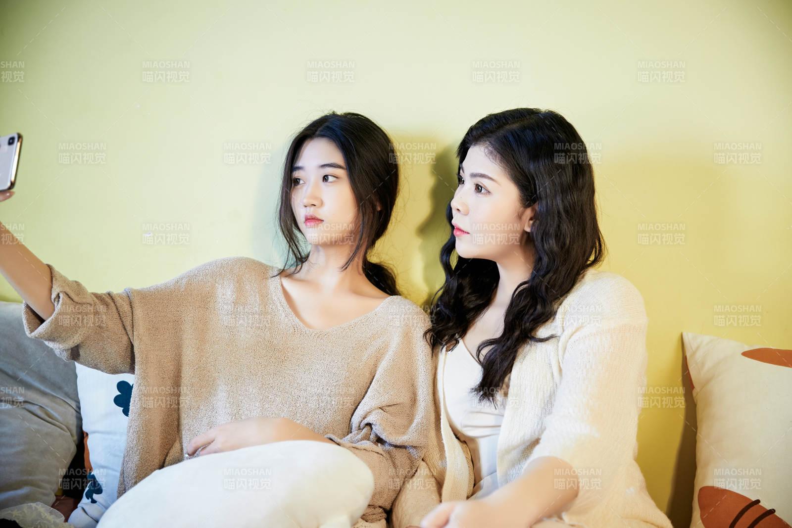 坐在床上玩手機(jī)的倆位美女