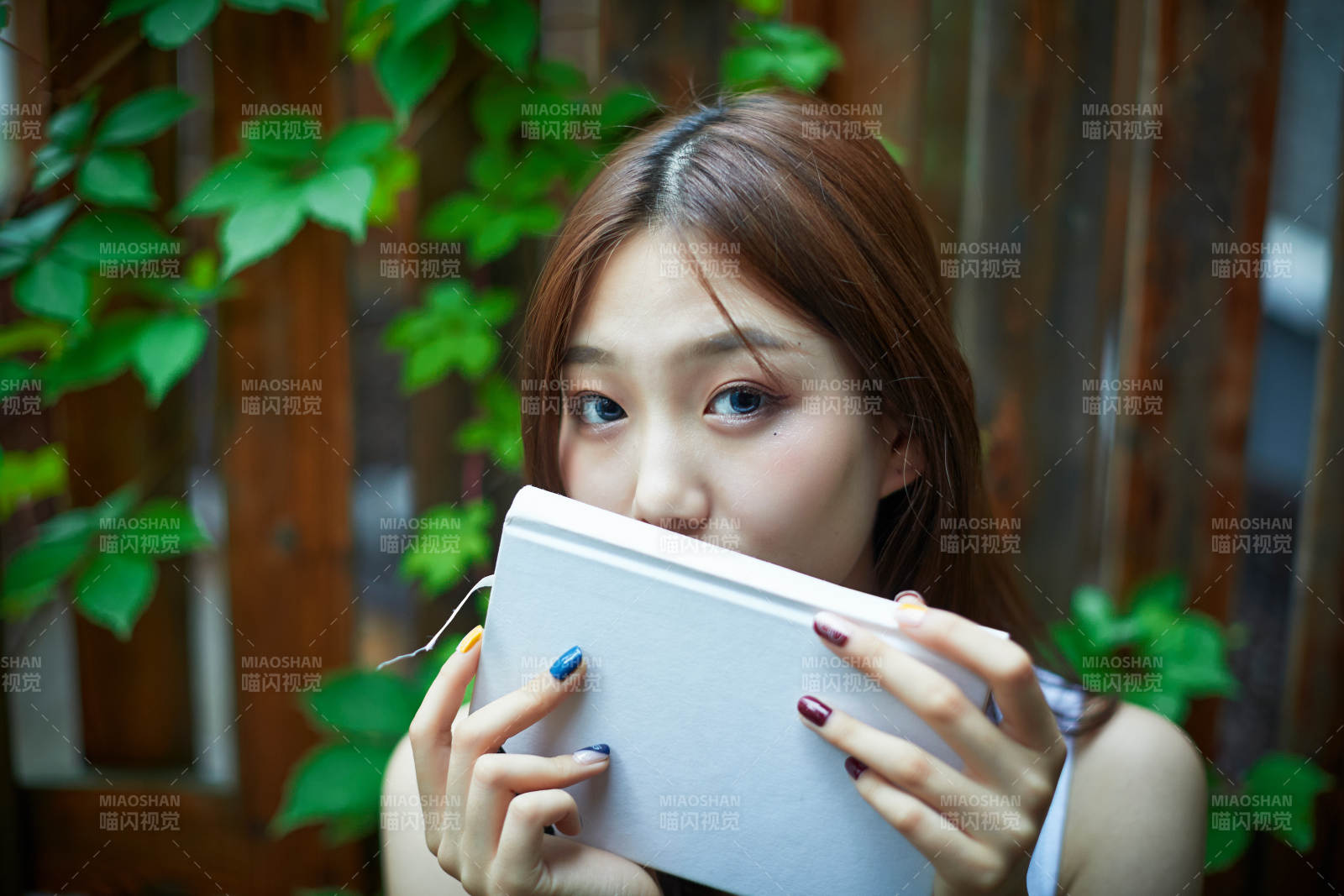 院子里坐在長椅上閱讀書籍的亞洲長發(fā)少女