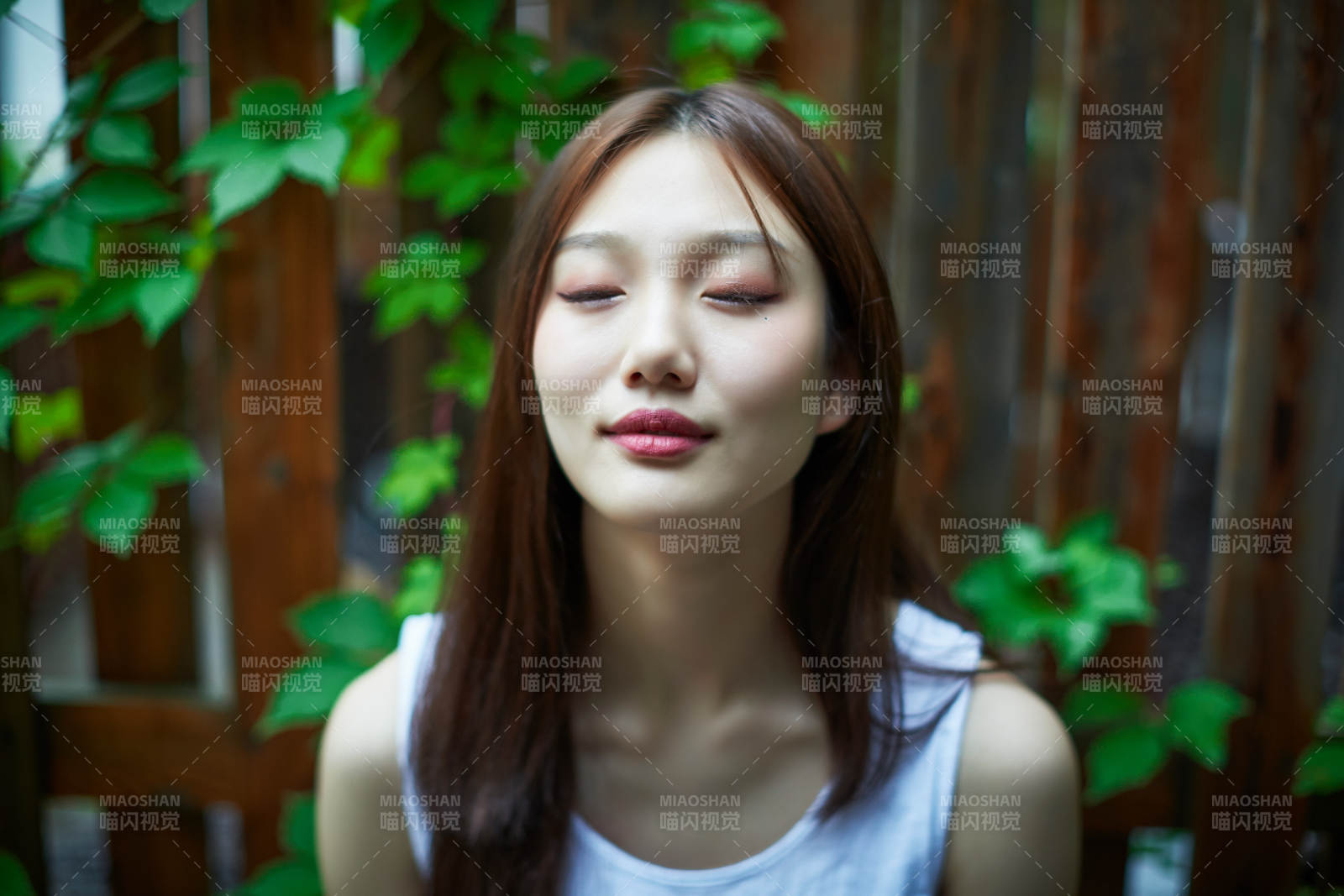 院子里坐在長(zhǎng)椅上閱讀書(shū)籍的亞洲長(zhǎng)發(fā)少女