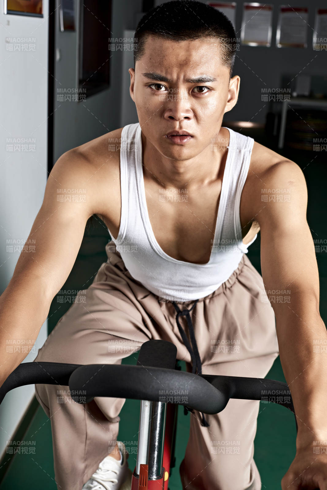 在室內(nèi)進(jìn)行動(dòng)感單車鍛煉的亞洲健身男士形象