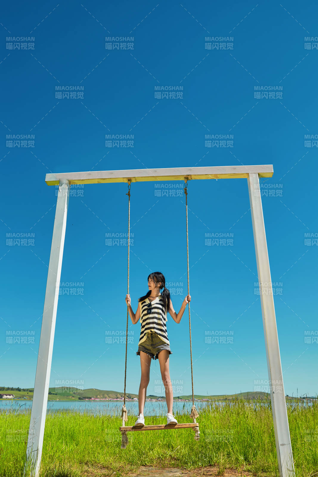 草原湖畔打卡点游玩拍照的亚洲少女