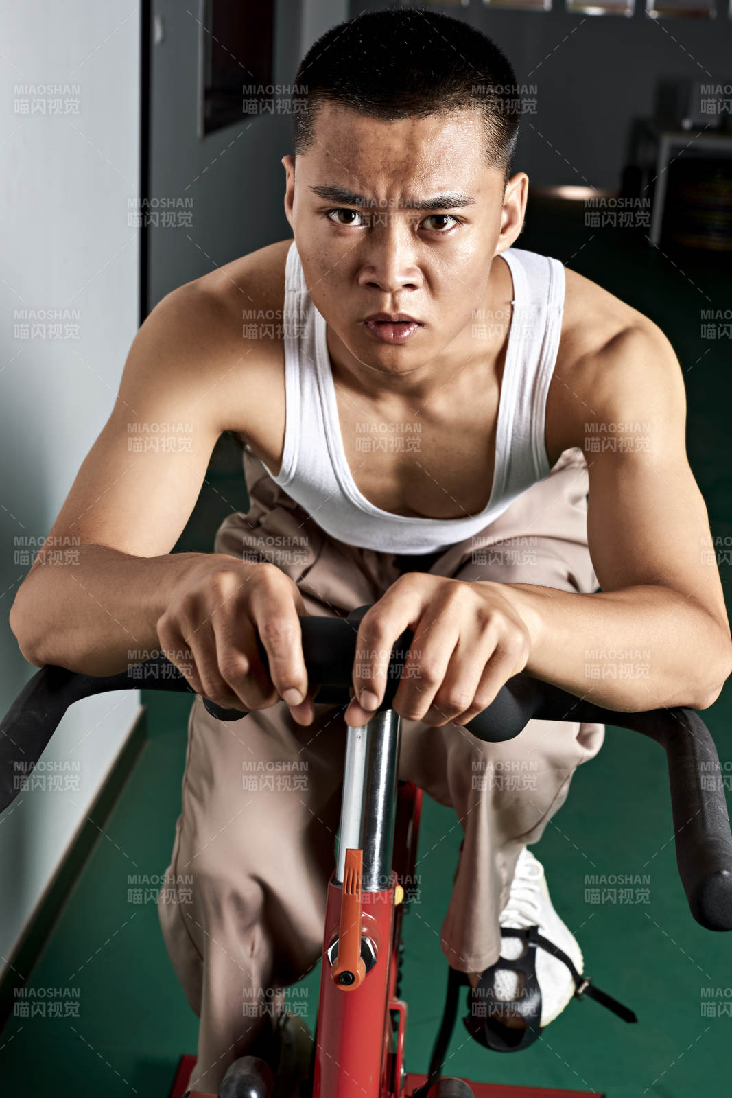 在室內進行動感單車鍛煉的亞洲健身男士形象
