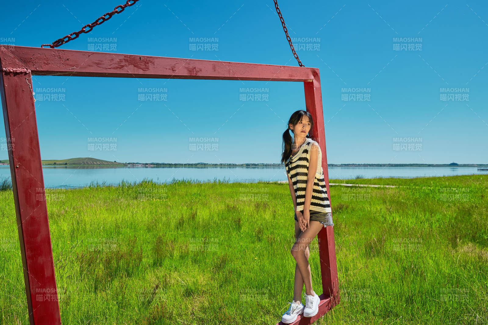 草原湖畔打卡點游玩拍照的亞洲少女