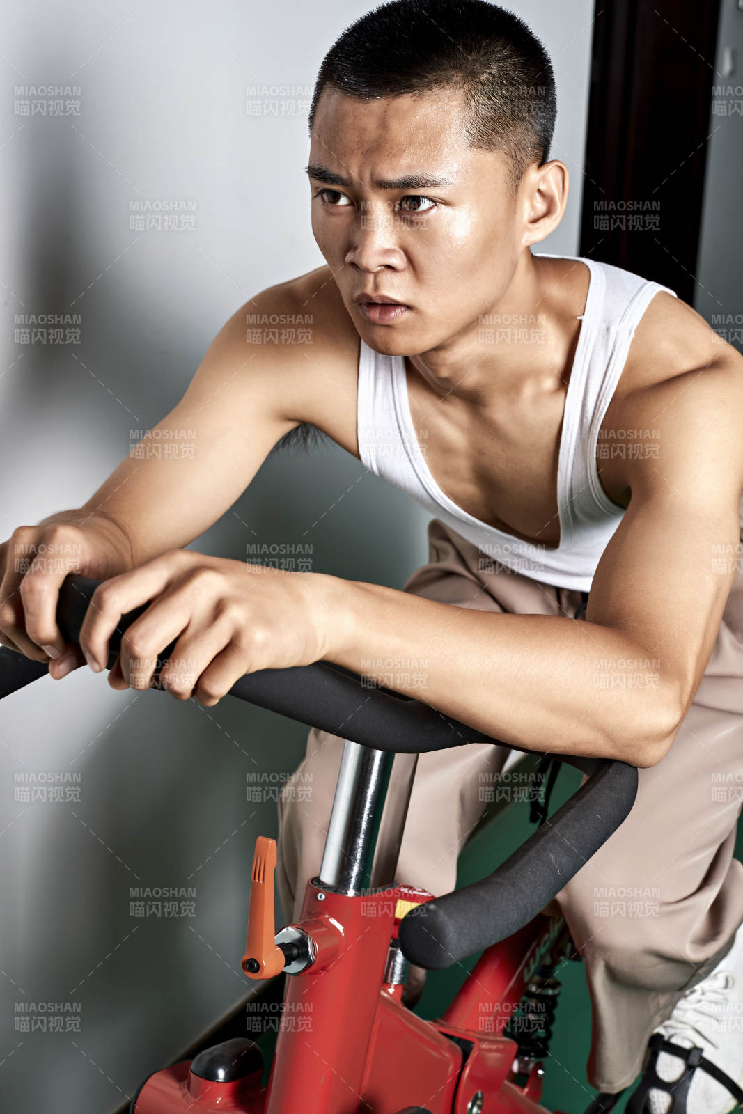 在室內進行動感單車鍛煉的亞洲健身男士形象