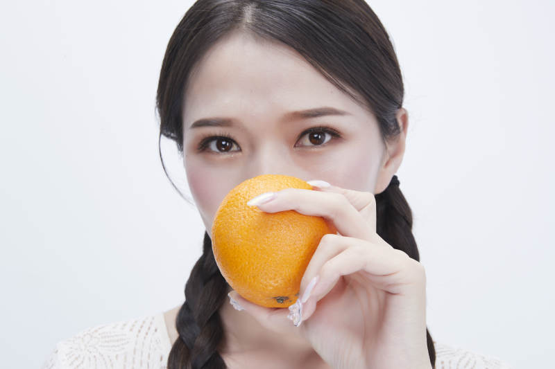 手拿橙子身穿镂空连衣裙的亚洲可爱少女人像