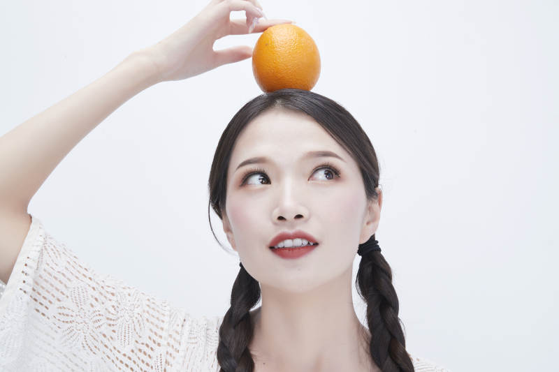 頭頂橙子身穿鏤空連衣裙的亞洲可愛少女人像