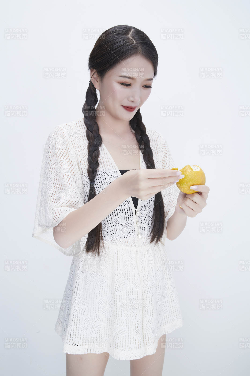 在剝橙子皮的身穿鏤空連衣裙的亞洲少女人像